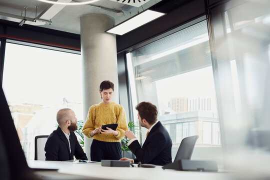 Colleagues discussing business strategy in a modern office boardroom