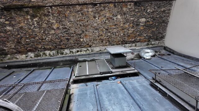 Paris Rooftop View With Stone Wall And Metal Structures Showing Urban Landscape And Architectural Details In A European Cityscape Setting Suitable For Travel Content