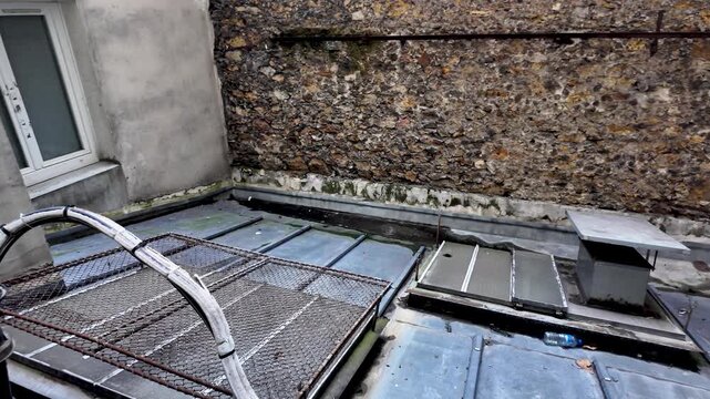 Paris rooftop showing old stone wall, zinc roof and ventilation duct