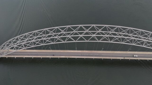 Aerial drone view of the Adomi Bridge near Akosombo Dam, Ghana. Cinematic shot of the iconic arch suspension bridge spanning the Volta River with traffic