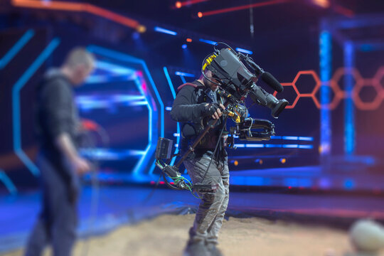 Professional Steadicam Operator in Stabilization Vest Filming Live Show in High-Tech Studio
