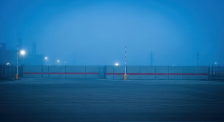 Obraz premium Misty blue cityscape featuring a road with barriers and soft lighting at dusk