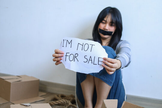 Female Human Trafficking Victim with Her Mouth Taped Shut Holds Sign That Ready "Im Not For Sale"
