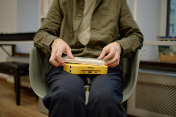 Middle aged Caucasian man using assistive device for visually impaired, focusing on accessible reading