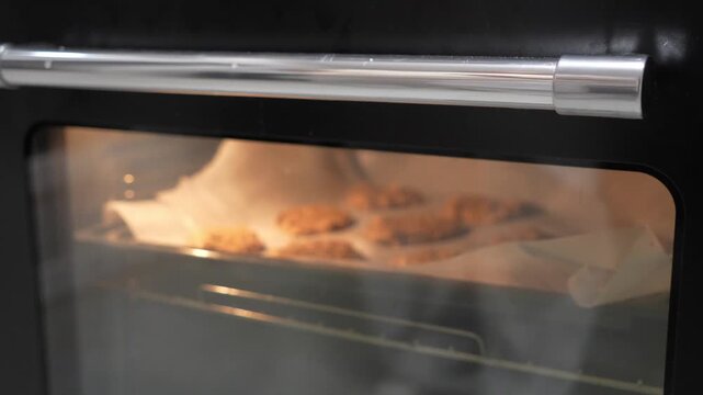 A tray of cookies is baking in an oven. The oven is set to 350 degrees. The cookies are golden brown and ready to be taken out