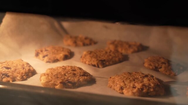 A tray of cookies is baking in an oven. The cookies are golden brown and appear to be ready to be taken out
