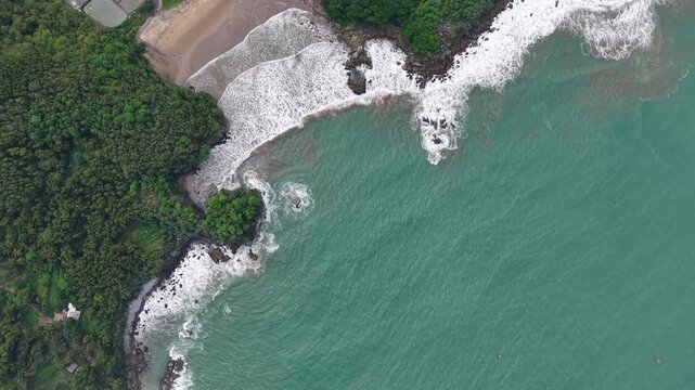 Aerial View of Tropical Coastline With Turquoise Ocean, Rocky Headland and Lush Forest
