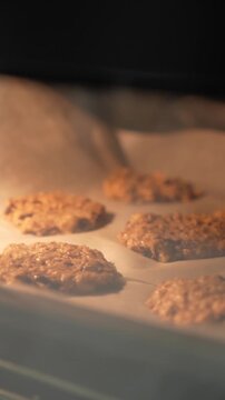 A tray of cookies is baking in an oven. The cookies are golden brown and appear to be ready