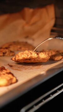 A tray of cookies is baking in an oven. The cookies are golden brown and appear to be ready to be taken out