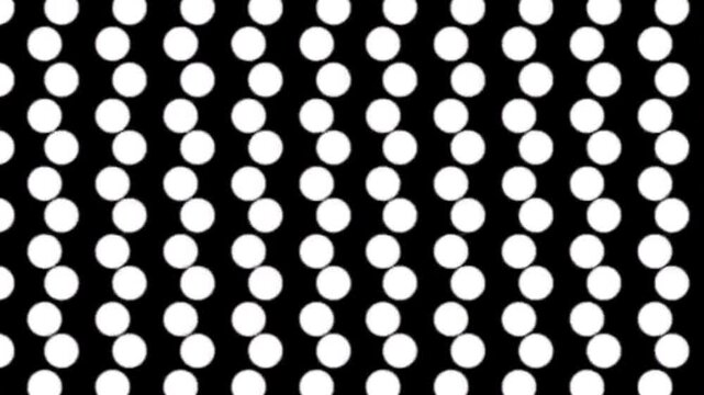 Seamless loop of white polka dots moving diagonally across a black background for motion graphics.