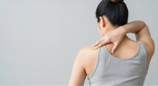 Woman feeling pain in shoulder and neck. Health problem and injury. Female massaging her back and shoulder. Suffering from body ache.