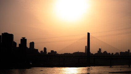 Obraz premium The silhouettes of city skyline under the sunlight during the sunset in Chongqing, China