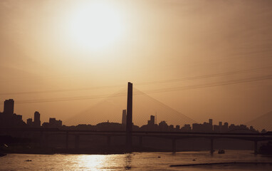 Obraz premium The silhouettes of city skyline under the sunlight during the sunset in Chongqing, China