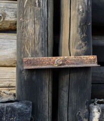 Fototapeta premium Rusty metal bolt securing old weathered wooden poles.