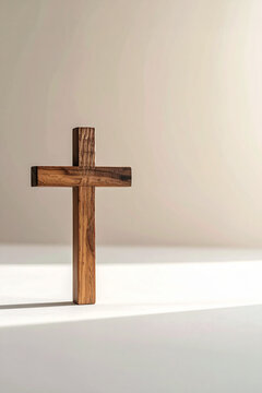 Croce in legno su superficie chiara con ombra morbida. Composizione semplice e simbolica, ideale per temi spiritualit&agrave;, fede, meditazione, minimalismo e design pulito.