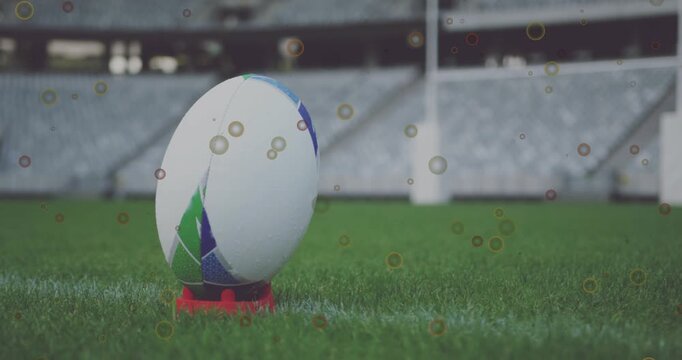 Sequence starting rugby ball rotating left on tee on yardline particles drifting in showing panels