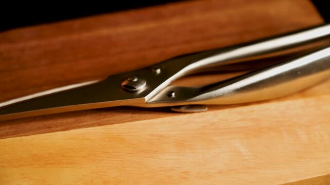 Using kitchen scissors to cut vegetables on a wooden cutting board in a bright kitchen setting