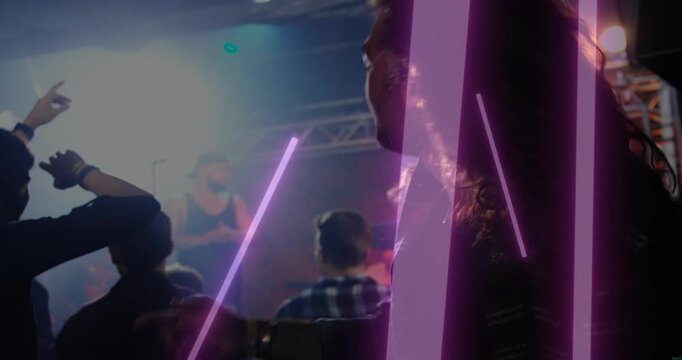 Long-haired male attendee headbanging to music, purple bars overlaying crowd, keyboardist right