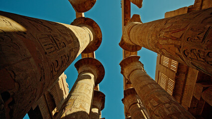 Naklejka premium Ancient columns of Karnak Temple in Luxor Egypt viewed from below at sunset