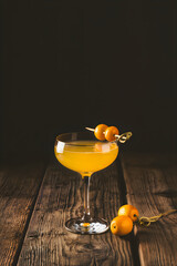Cocktail with orange fruit garnish on wooden table