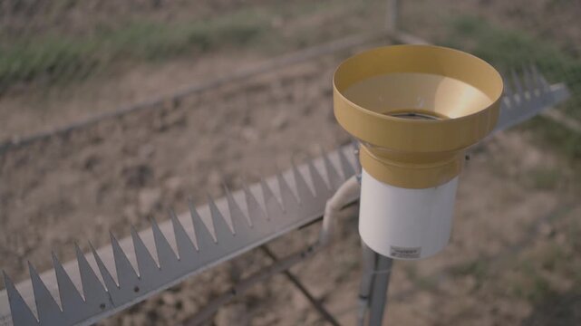 A weather monitoring system with a rain gauge and Stevenson screen in Sindh Pakistan It is used for agricultural and environmental data collection and analysis.