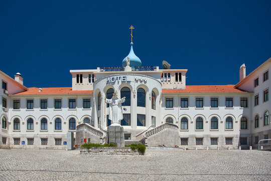 Front facade of the Domus Pacis Hotel with a statue of the Virgin Mary and a blue domed roof, Fatima, Santarem, Portugal, Europe.