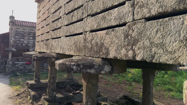 Slow cinematic camera approach to ancient stone horreo in Galicia