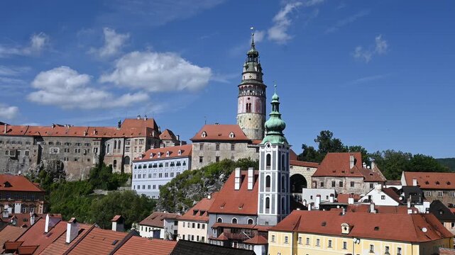 Panoramic Sunset City View of Cesky Krumlov during sunset. The footage captures the historic castle, the iconic round tower, and the red-roofed medieval houses nestled along the Vltava river.