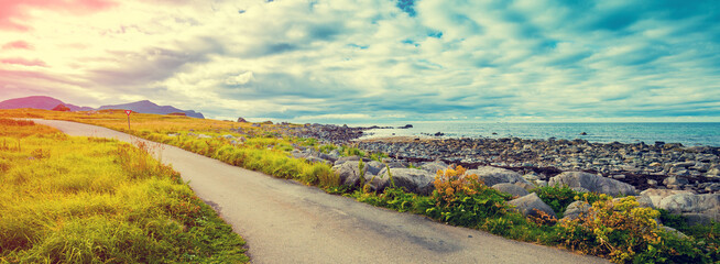 The road along the fjord with the dramatic stormy cloudy sky. Beautiful nature Norway.