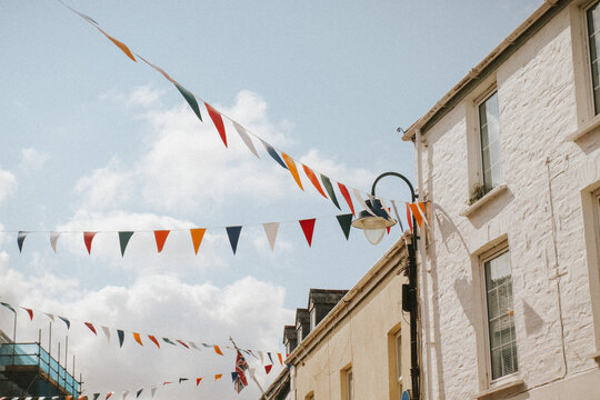 colourful flags in quaint Cornwall town on sunny day