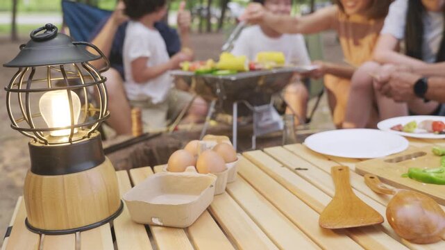 Family enjoys camp summer eat food picnic, multigenerational group shares happy travel moments grilling fresh vegetables meat skewers outdoors for vacation relaxation.