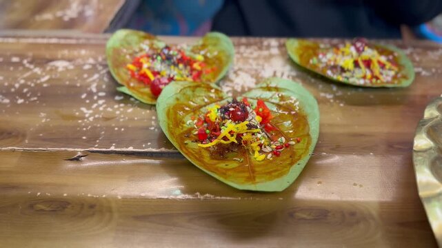 Closeup view of freshly prepared meetha paan arranged on a wooden counter