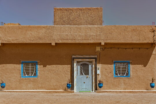 Closed blue door and grilled windows of a traditional adobe-walled Amazigh (Berber) house in Khamlia village, next to Erg Chebbi. Merzouga-Morocco-142
