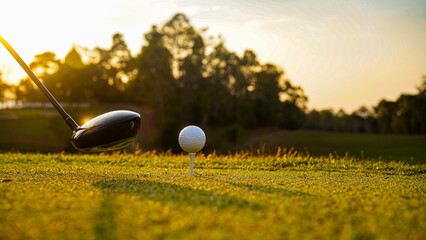 Golf Driver Preparing to Hit a Ball at Sunset with Trees in Background © ChampZ