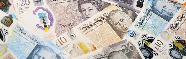 Obraz premium British pound money bills pile on table. United Kingdom banknotes of GBP currency close up.