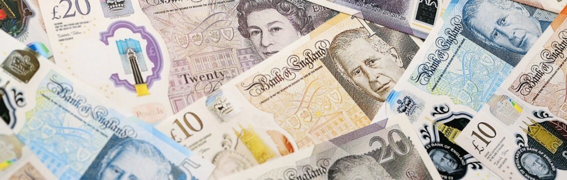 British pound money bills pile on table. United Kingdom banknotes of GBP currency close up.