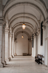 Obraz premium Historic arched corridor with hanging lanterns and stone columns