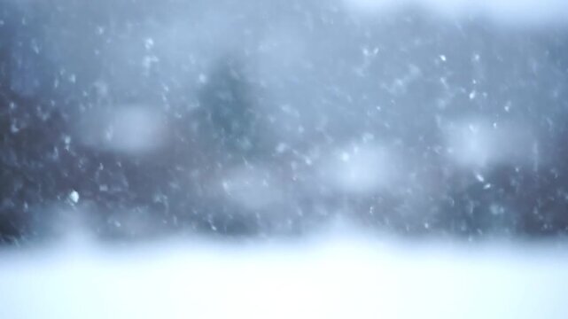 Snowflakes falling gently on a serene winter landscape viewed from a close distance