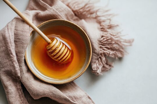Golden honey mead in a bowl with a wooden dipper and linen texture, showcasing natural sweetness and rustic preparation for enjoyment.