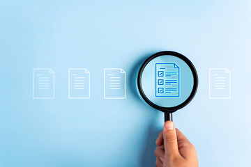 Close up to hand, hold magnifier to search file to management about document is important business.