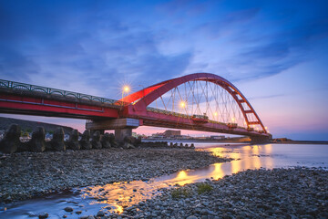 Fototapeta premium Coast Landscape at Rainbow Bridge (Caihong Bridge) in Evening - Long exposure at sunset, shot in Taoyuan, Taiwan.
