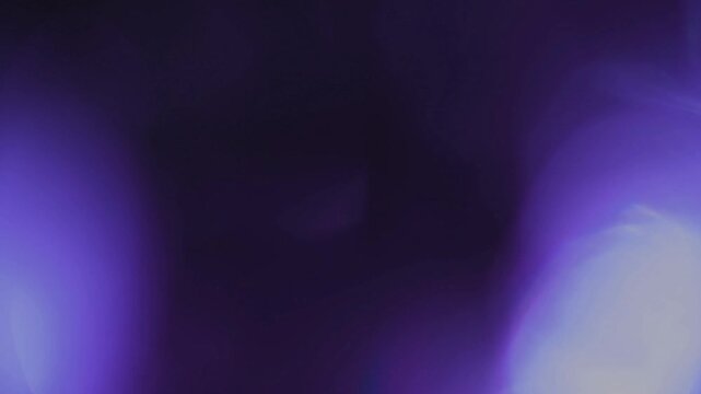 Light leak and bokeh overlay with purple hues and soft glow. This footage can be used as a creative element or transition in video editing.