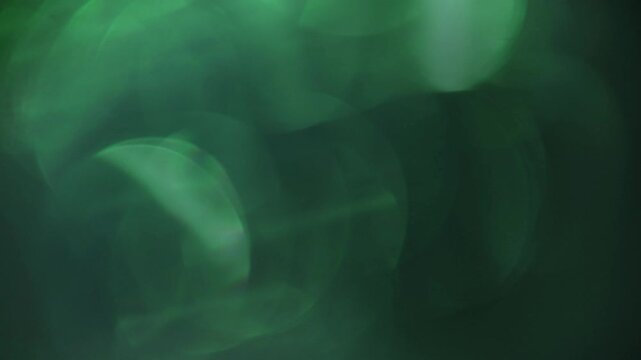 Light leak and bokeh overlay with soft green hues and dark tones for cinematic effects. Perfect for adding atmosphere and mood to projects.