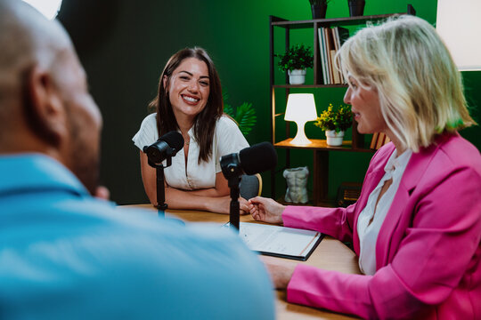 Diverse people broadcasting live podcast interview using microphones