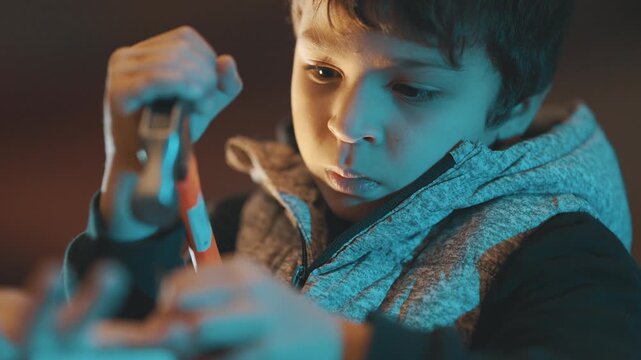 Focused young boy repairing with pliers