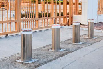 Row of modern automatic retractable bollards rising from asphalt, creating a barrier for access control and enhancing security at an entrance