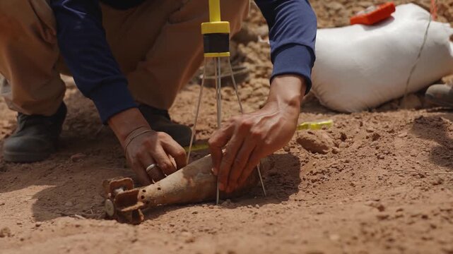 The researcher is examining an old unexploded bomb