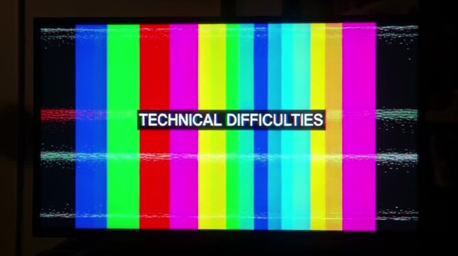 Technical difficulties screen with vibrant color bars and glitch effect
