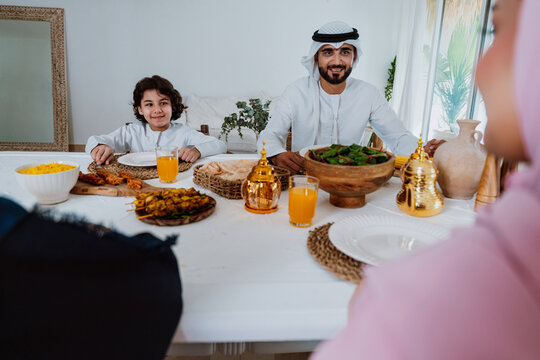 Muslim father son enjoying iftar dinner together