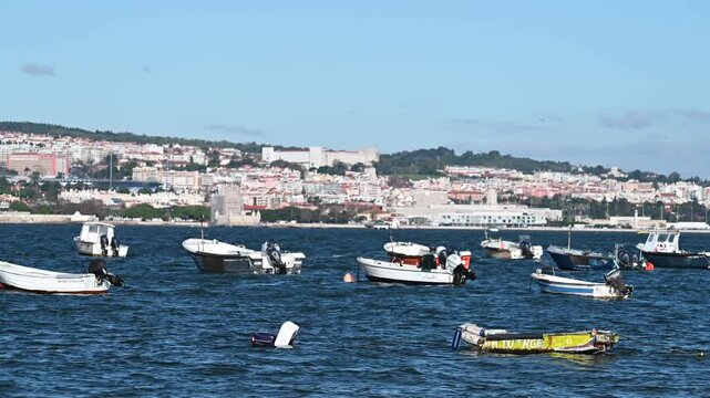 Multiple small boats floating across Tagus River channel